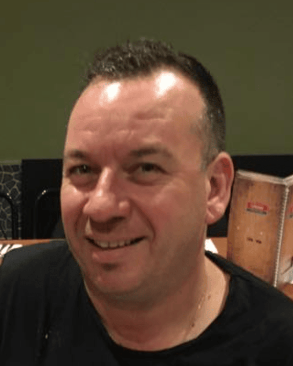 Frank Dinatale - Professional headshot of Fast Melbourne Towing's founder wearing a black polo shirt, smiling warmly at the camera. Frank brings over 30 years of towing and automotive expertise to Melbourne's roads.