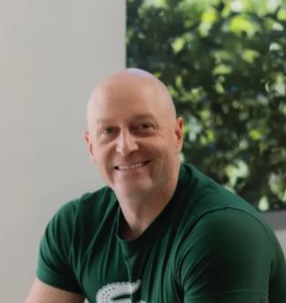 Levi Saunders, marketing specialist and HR licensed driver at Fast Melbourne Towing, wearing a green t-shirt and smiling warmly at the camera